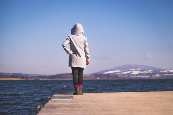 Fiatal Lány Szürke Kabátban Áll Egy Gyaloghídon Élvezi Kilátást Tóra — Stock Fotó