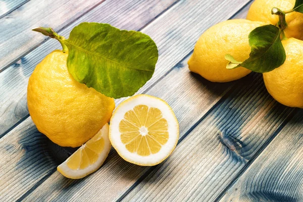 古い木製のテーブルの上に葉を持つ熟したレモンの閉鎖 健康的な栄養 — ストック写真