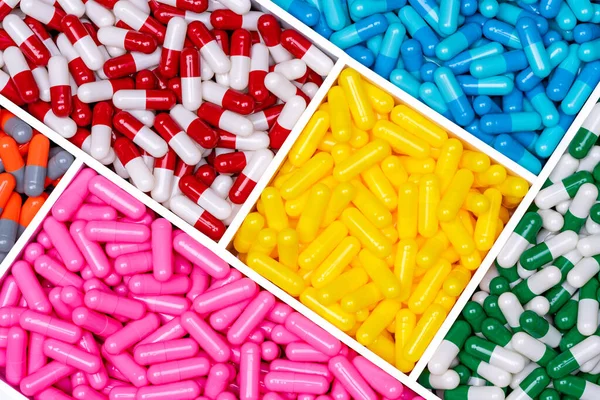 Top View Kapszula Tabletták Műanyag Dobozban Sárga Rózsaszín Kék Piros — Stock Fotó