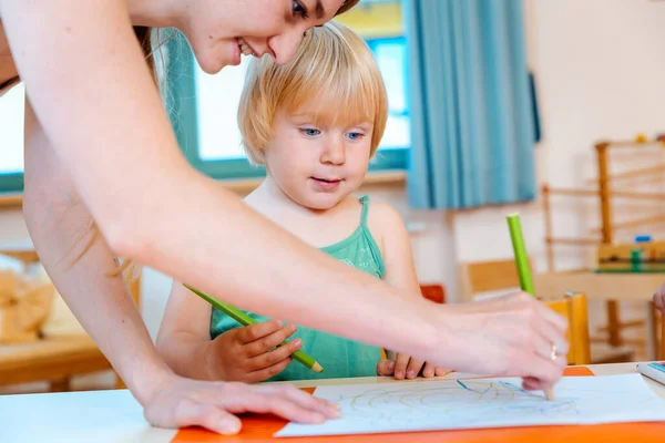 Oyun Okulunda Kalemle Çizim Yapan Çocuklara Öğretmen Yardım Eder — Stok fotoğraf