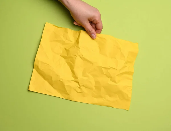 Γυναικείο Χέρι Κρατώντας Λευκό Τσαλακωμένο Κίτρινο Φύλλο Χαρτιού Πράσινο Φόντο — Φωτογραφία Αρχείου