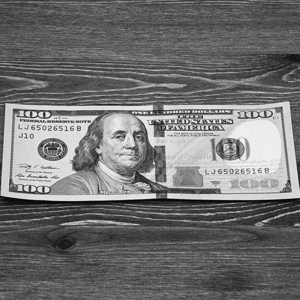 一张100美元的钞票放在一张深色木桌上 Mockup — 图库照片