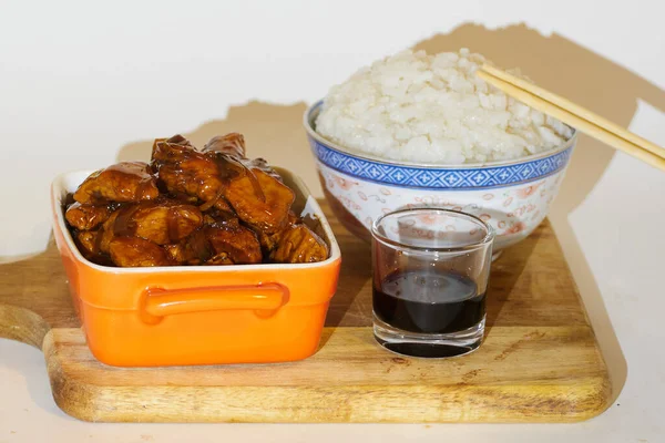韩国烤鸡肉 用橙色铝制容器和一碗白饭 玻璃杯牡蛎酱和白色背景的亚洲筷子 — 图库照片