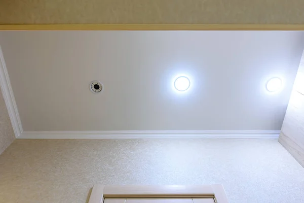 廊下に白いマットの天井を伸ばし ランプの1つが燃え尽きてねじれた — ストック写真