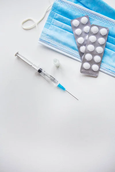 为Covid 19疫苗接种做准备 注射器 白色桌子上的医疗面具 从上面看 — 图库照片