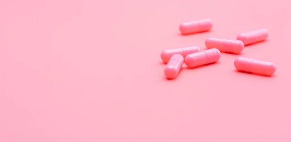 粉红胶囊的粉红背景药丸 维生素和补充剂 在线药房 药店的横幅 制药工业 妇女健康保险概念 爱情和幸福生活的药丸 — 图库照片