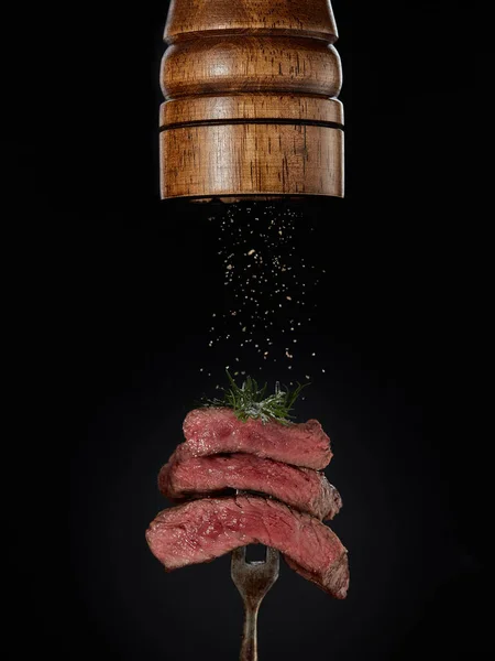 Kızarmış Biber Değirmeninden Izgara Biftek Parçalarının Üzerine Dökülen Öğütülmüş Baharatlar — Stok fotoğraf