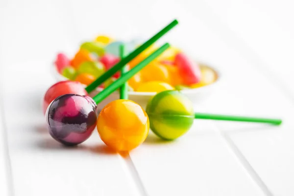 白桌子上的甜果香 棒棒糖和果冻豆 — 图库照片