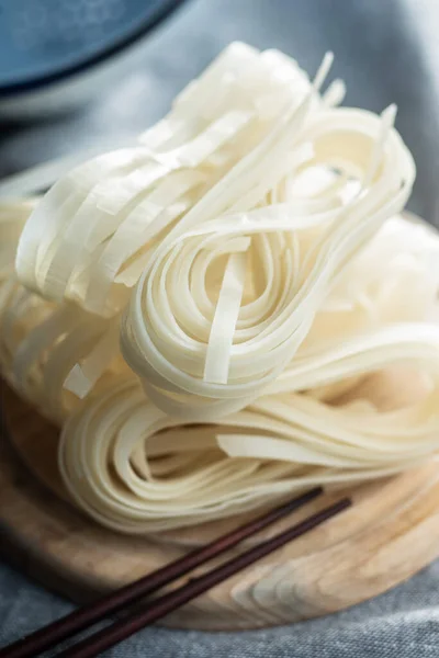 乾燥した白い米麺 生パスタ まな板上の調理されていない麺 — ストック写真
