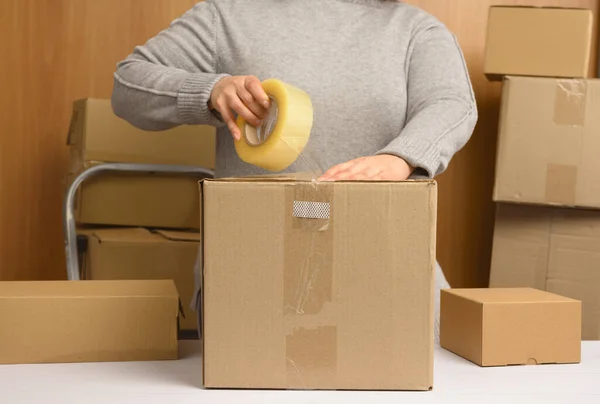 Woman Gray Sweater Holds Roll Duct Tape Packs Brown Cardboard — Stock Photo, Image