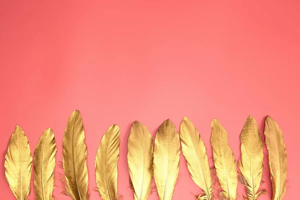 Gouden Glanzende Veren Een Rij Pastelroze Achtergrond Vlakke Lay Retro — Stockfoto