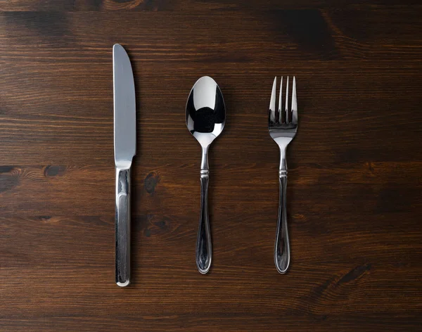 木桌上的勺子 叉子和刀 从上面看 — 图库照片