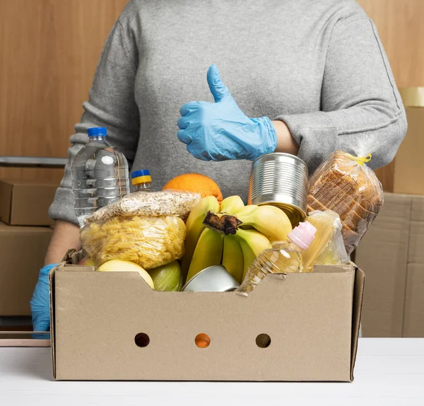 Žena Rukavicích Stále Sbírá Jídlo Ovoce Věci Kartónovou Krabici Pro — Stock fotografie