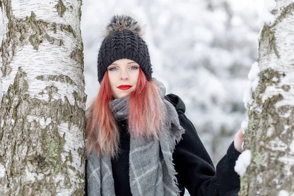 冬日里 一个迷人的红头发姑娘站在两根桦树之间的画像 — 图库照片