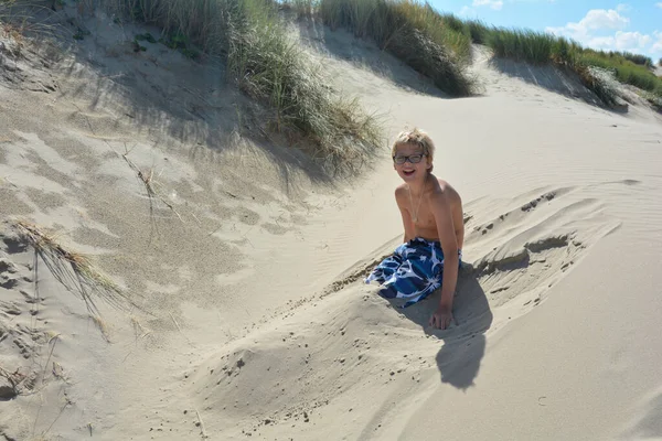 Αγόρι Κάθεται Στους Αμμόλοφους Και Έχει Πόδια Του Στην Άμμο — Φωτογραφία Αρχείου