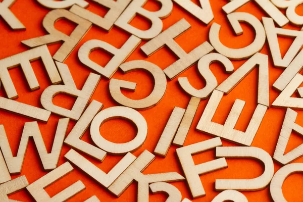 Detailaufnahme Von Vielen Aus Holz Geschnittenen Kleinen Buchstaben Auf Orangefarbenem — Stockfoto