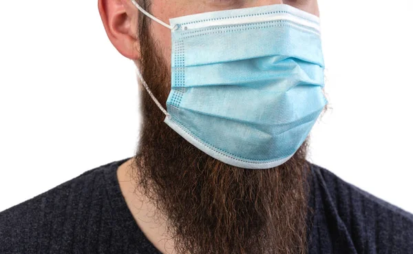 白の背景に隔離された汚染や伝染性のウイルスや病気を避けるために保護または外科マスクを身に着けている白人の若いひげを生やした成人男性 コロナウイルス 流行の概念 — ストック写真