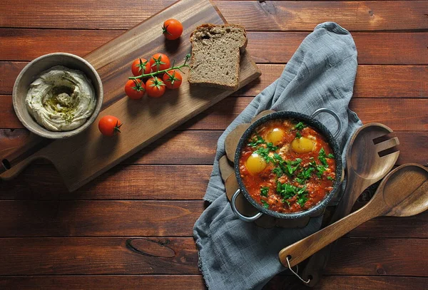 Shakshuka Pánvi Humusem Hnědém Dřevěném Pozadí Středovýchodní Jídla Tradiční Izraelské — Stock fotografie