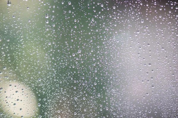 雨点落在有抽象灯光的窗户上 — 图库照片