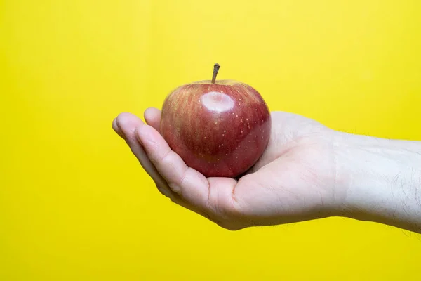 Mano Sosteniendo Una Manzana Verde Sobre Fondo Amarillo — Foto de Stock