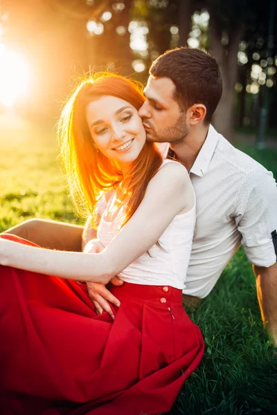 日没の夏の公園でキスをするカップルが大好きです 魅力的な女性と若い男のロマンチックなデート — ストック写真