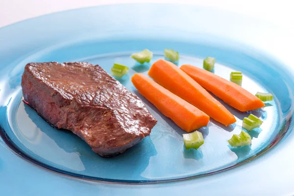 Roasted Ostrich Meat Carrots Celery Blue Glass Plate — Stock Photo, Image