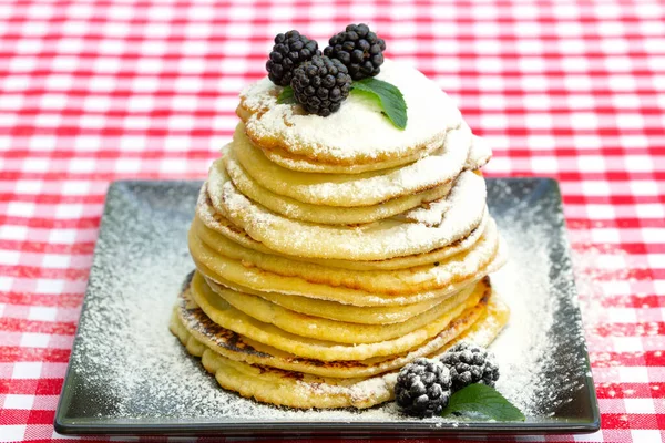 Pfannkuchen Mit Brombeeren Und Puderzucker Auf Einem Schwarzen Teller Karierte — Stockfoto