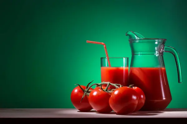 Glas Und Karaffe Mit Tomaten Auf Grünem Hintergrund — Stockfoto