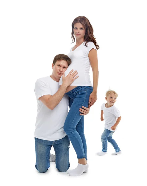 友好的家庭 丈夫拥抱着怀孕的妻子 快乐的小儿子在父母身边跑来跑去 孤身一人 背景是白色的 快乐的父母怀孕的母亲和有孩子的父亲 — 图库照片