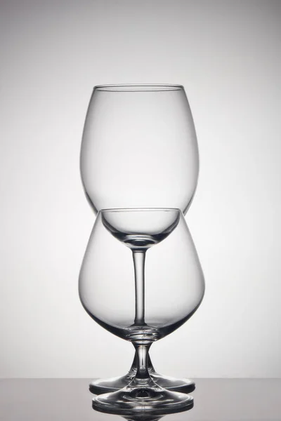 クリアガラス器 空のガラスのためのワインとコニャック上の灰色の背景 — ストック写真