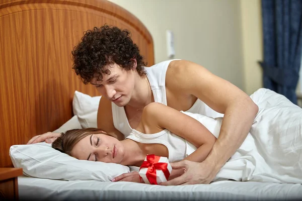 Família Jovem Feliz Com Caixa Presente Encontra Cama Casa Dia — Fotografia de Stock