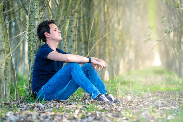 Joven Sentado Junto Árbol Bosque Pensando Vida Descanso —  Fotos de Stock
