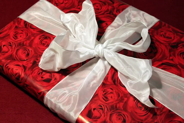 红玫瑰包装纸和白蝴蝶结礼物 — 图库照片
