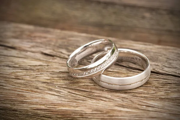 木桌上的结婚戒指 — 图库照片