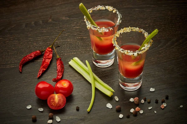 两杯配上鸡尾酒血腥玛丽 香料和成熟的西红柿 深色木制背景 顶部视图 — 图库照片
