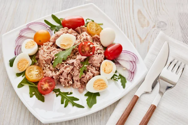 Tonijnsalade Met Rucola Tomaten Witte Plaat Lichte Houten Ondergrond Bovenaanzicht — Stockfoto