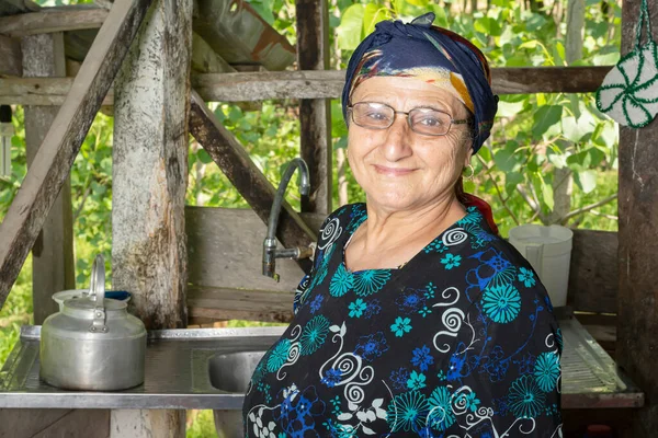 在农村地区厨房里一个戴着眼镜的快乐的穆斯林老年妇女的画像 — 图库照片
