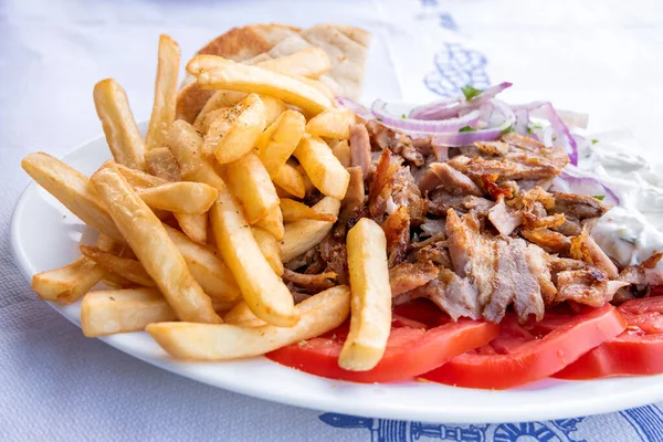 ギリシャのスブラキ ギリシャの伝統的な食べ物 玉ねぎとツァッツィキソースの豚肉とフランスのフライドポテト — ストック写真