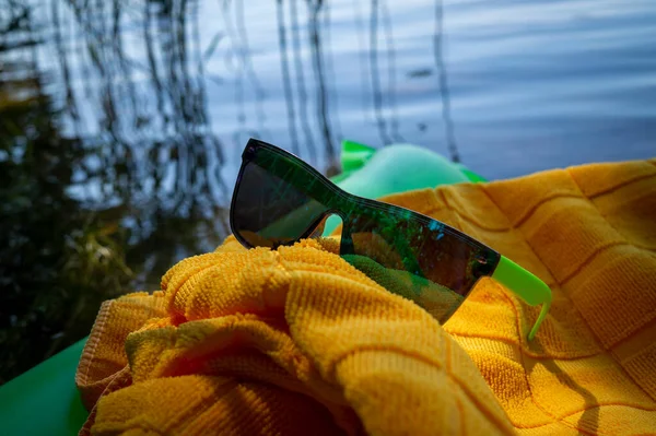Solglasögon Gul Handduk Placerad Grön Uppblåsbar Madrass Flytande Vatten Ett — Stockfoto