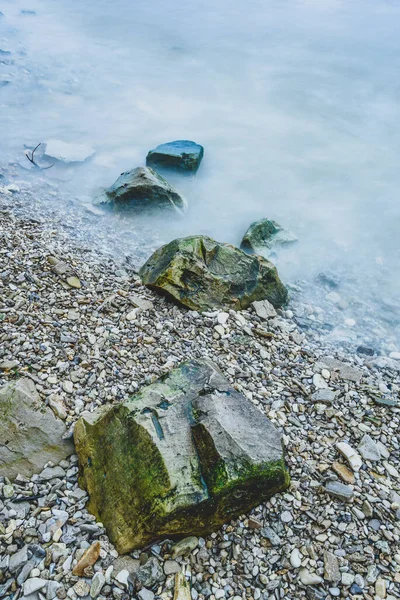 川沿岸の波の泡の岩の行 — ストック写真