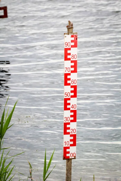 A yardstick for measuring the water level. Water level measurement on a body of water.