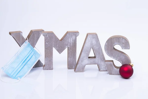 这张照片显示的是 Mas 这个词 它是用带有保护膜和圣诞球的木制字母写成的 — 图库照片