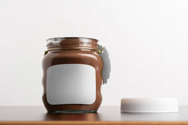Hazelnut Menyebarkan Toples Coklat Dengan Tutup Bulat Atas Meja Hitam — Stok Foto