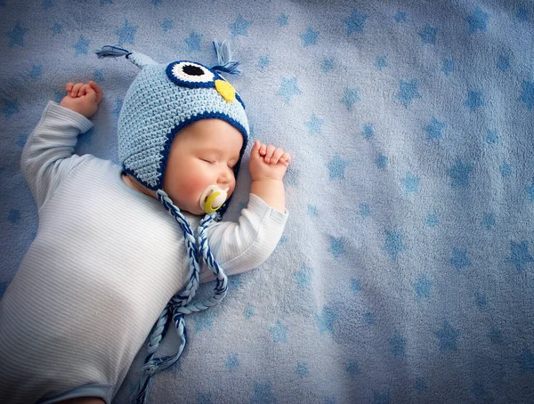 4ヶ月古いです赤ちゃんでフクロウ帽子寝て上の青毛布 — ストック写真