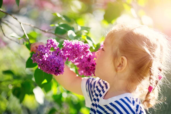 Criança Cheirando Flores Lilás Belo Dia Primavera Menina Bonito Livre — Fotografia de Stock