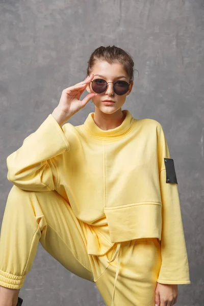 Mujer Joven Con Sudadera Amarilla Gafas Sol Sobre Fondo Gris —  Fotos de Stock