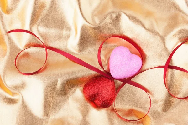 Rote Und Rosa Herz Und Satinbänder Liegen Auf Goldenem Hintergrund — Stockfoto