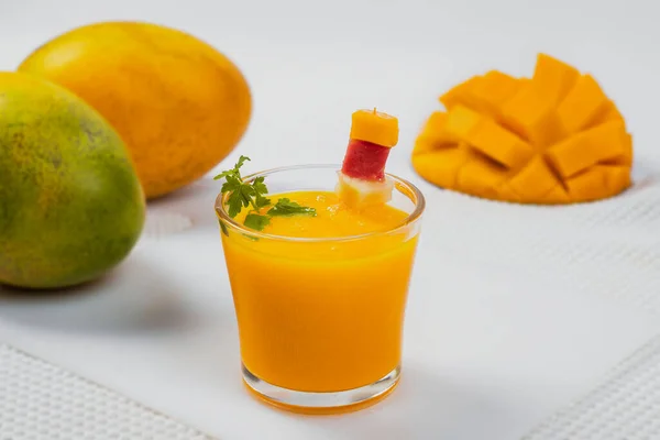 Een Glas Gevuld Met Mangosap Voorgrond Achtergrond Twee Hele Mango — Stockfoto