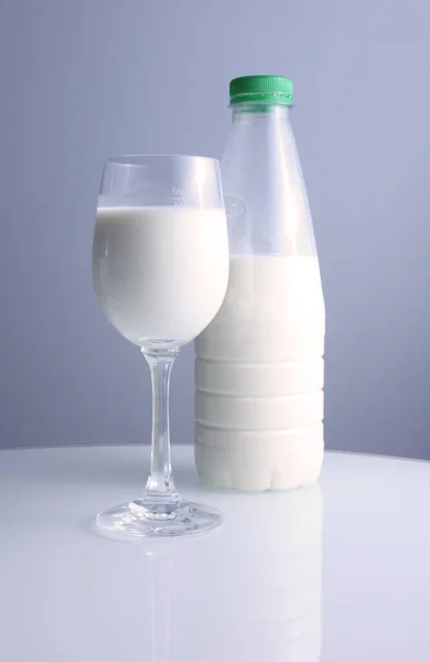 Glas Mjölk Och Flaska Vitt Och Blått Isolerad Grön Bakgrund — Stockfoto