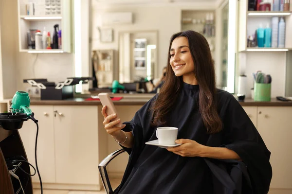 Cliente Femminile Sorridente Con Telefono Tazza Caffè Nel Salone Parrucchiere — Foto Stock